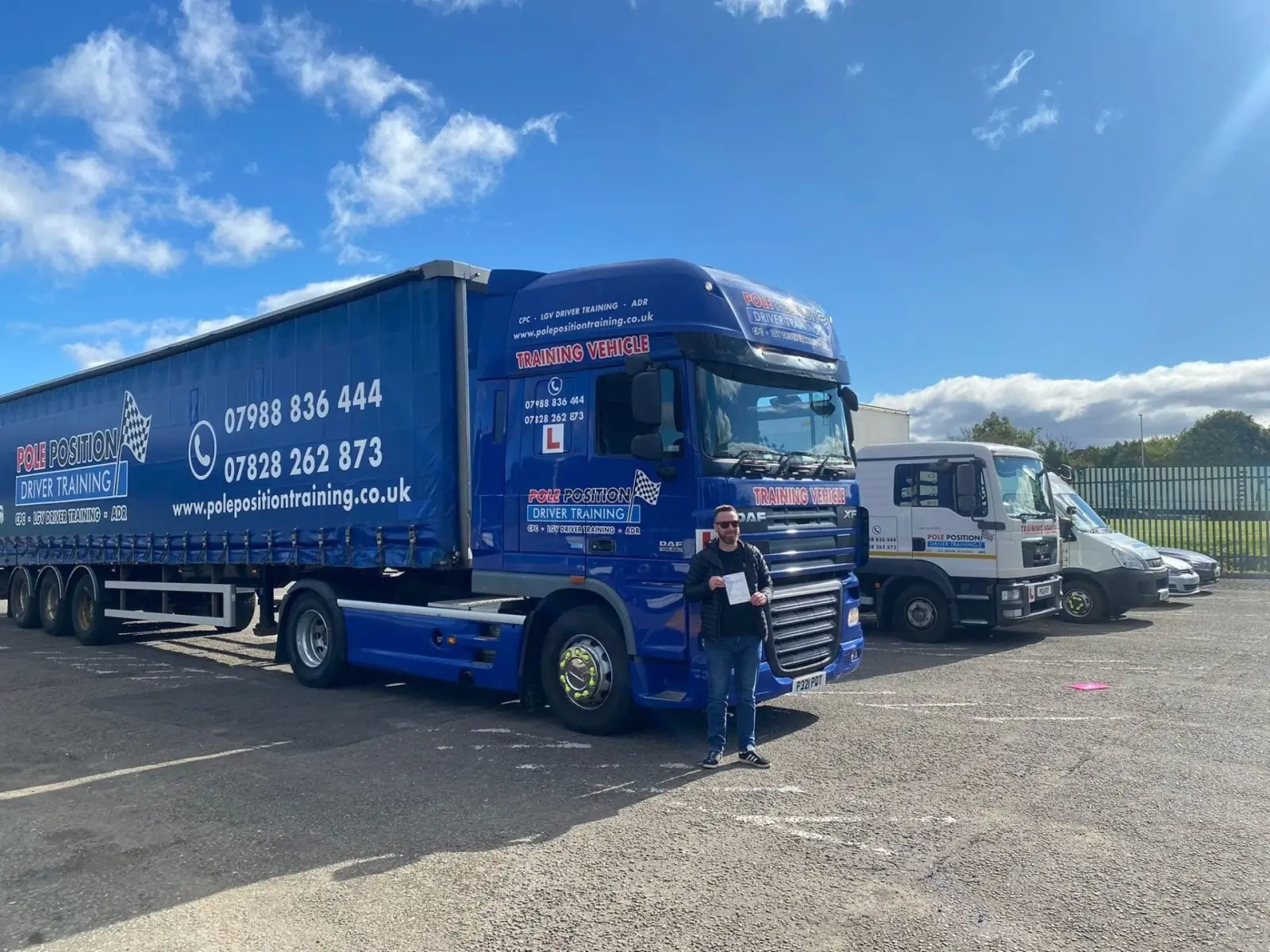 Driver beside a blue articulated lorry at Pole Position Driver Training Livingston